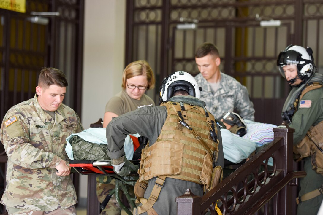 Service members transport a patient on a gurney in Puerto Rico.