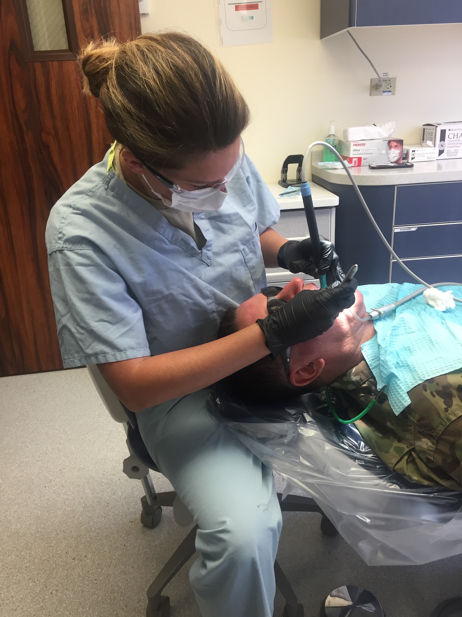 U.S. Air Force Technical Sgt. Nicole Cafarelli, dental hygienist in the New York Air National Guard's 106th Rescue Wing, is cleaning a patients teeth at Joint Base Pearl Harbor-Hickam in Hawaii Aug. 29, 2017. The medical technicians on the deployment for training received hands-on experience in providing patient care under the supervision of skilled preceptors.