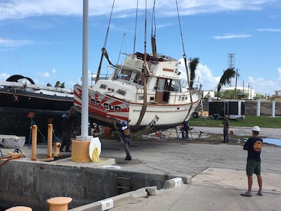 Image: Boat on a crane lift being maneuvered near Naval Air Station Key West after hurricane Irma.