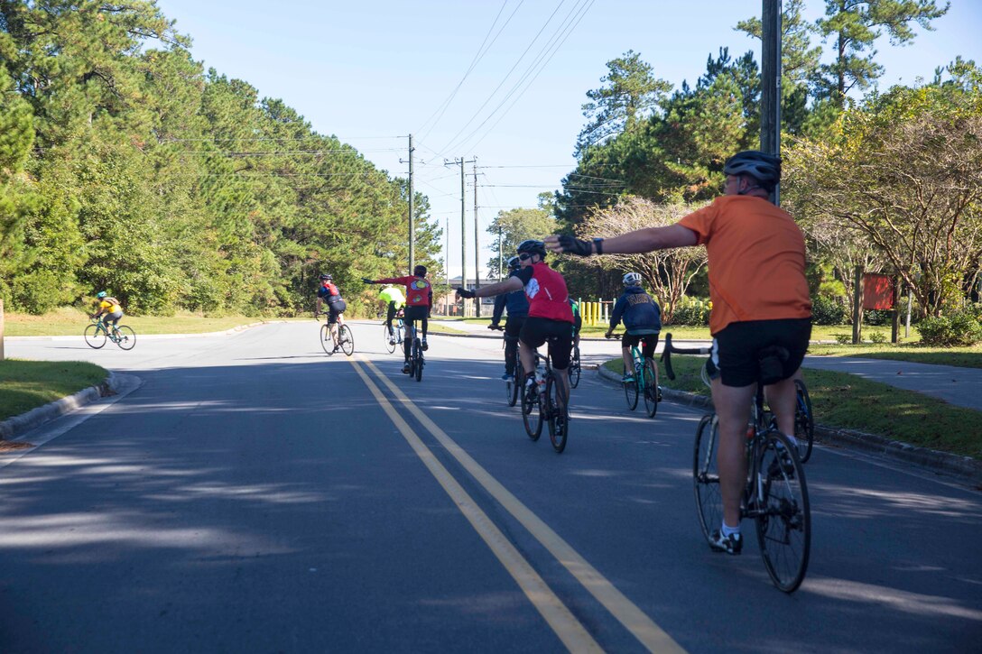 Marines and Sailors signal for a left turn during 2nd Marine Logistics Group’s unit bike ride at Camp Lejeune, N.C. Oct. 18, 2017. The bike ride afforded participants the opportunity to come together and strengthen unit cohesion and camaraderie. The Participants are with 2nd Marine Logistics Group. (U.S. Marine Corps photo by Pfc. Nicholas Guevara)