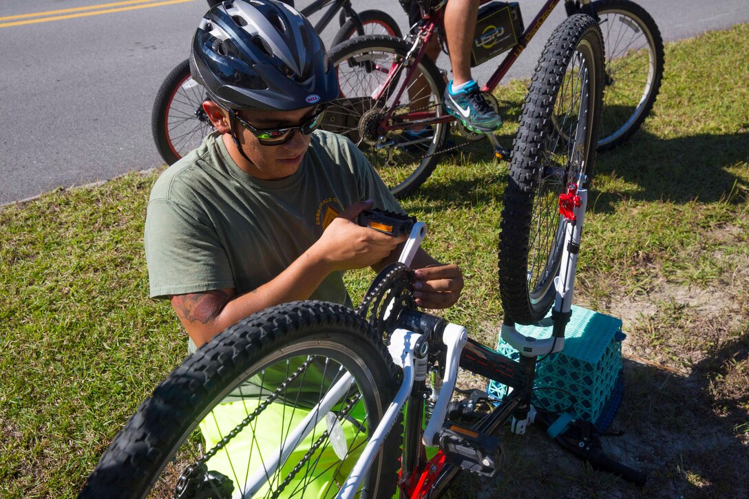 A Marine fixes his bike chain during a unit bike ride at Camp Lejeune, N.C. Oct. 18, 2017. The bike ride afforded participants the opportunity to come together and strengthen unit cohesion and camaraderie. The Participants are with 2nd Marine Logistics Group. (U.S. Marine Corps photo by Pfc. Nicholas Guevara)