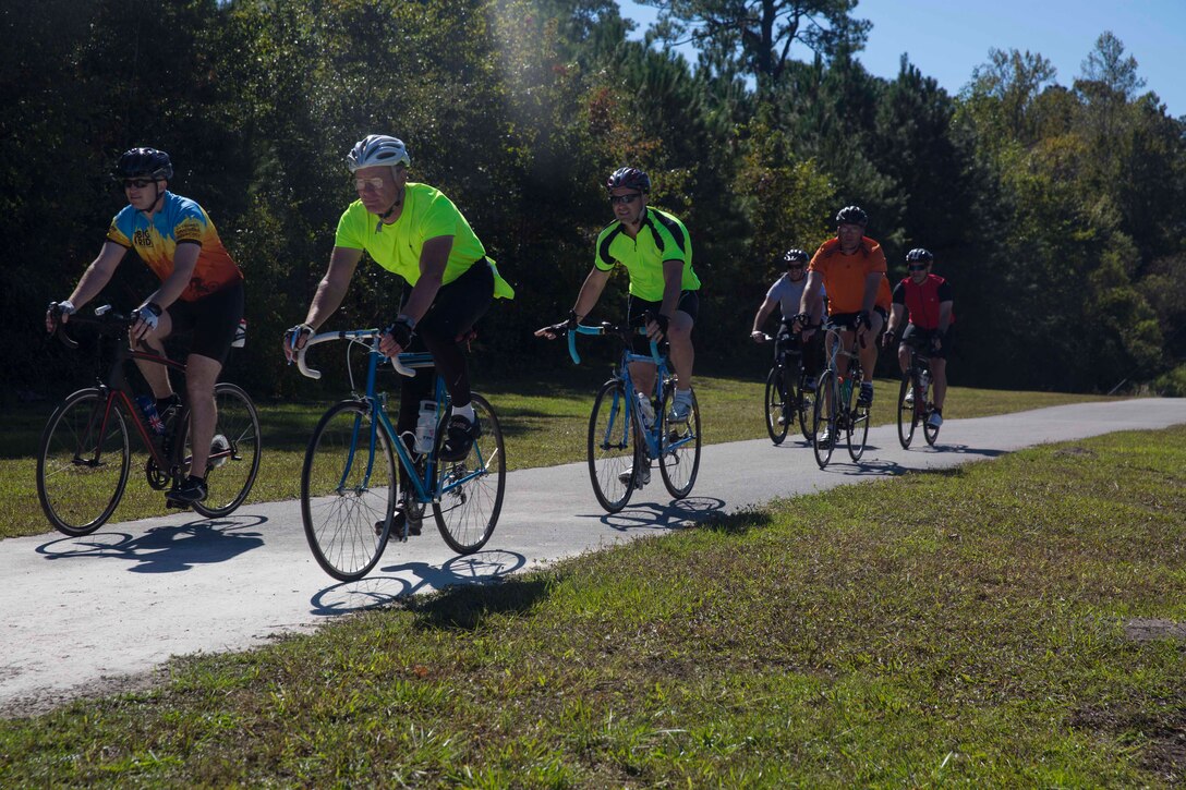 Marines and Sailors ride down trail during a unit bike ride at Camp Lejeune, N.C. Oct. 18, 2017. The bike ride afforded participants the opportunity to come together and strengthen unit cohesion and camaraderie. The Participants are with 2nd Marine Logistics Group. (U.S. Marine Corps photo by Pfc. Nicholas Guevara)
