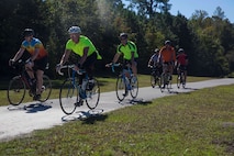 Marines and Sailors ride down trail during a unit bike ride at Camp Lejeune, N.C. Oct. 18, 2017. The bike ride afforded participants the opportunity to come together and strengthen unit cohesion and camaraderie. The Participants are with 2nd Marine Logistics Group. (U.S. Marine Corps photo by Pfc. Nicholas Guevara)