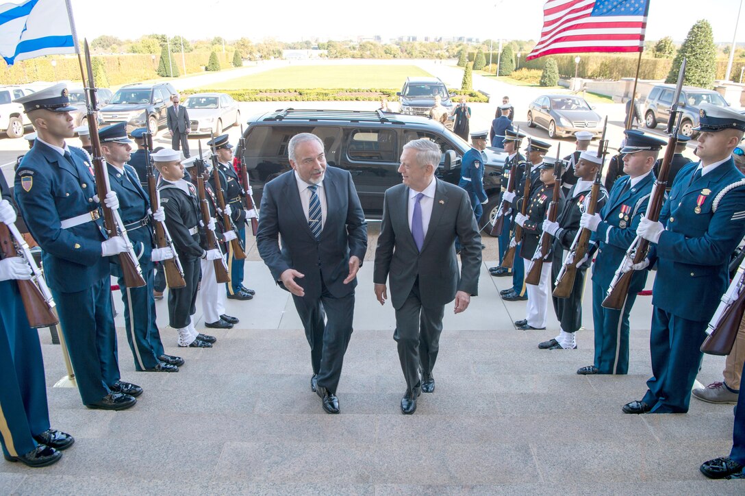 Defense Secretary Jim Mattis walks with a person up steps.