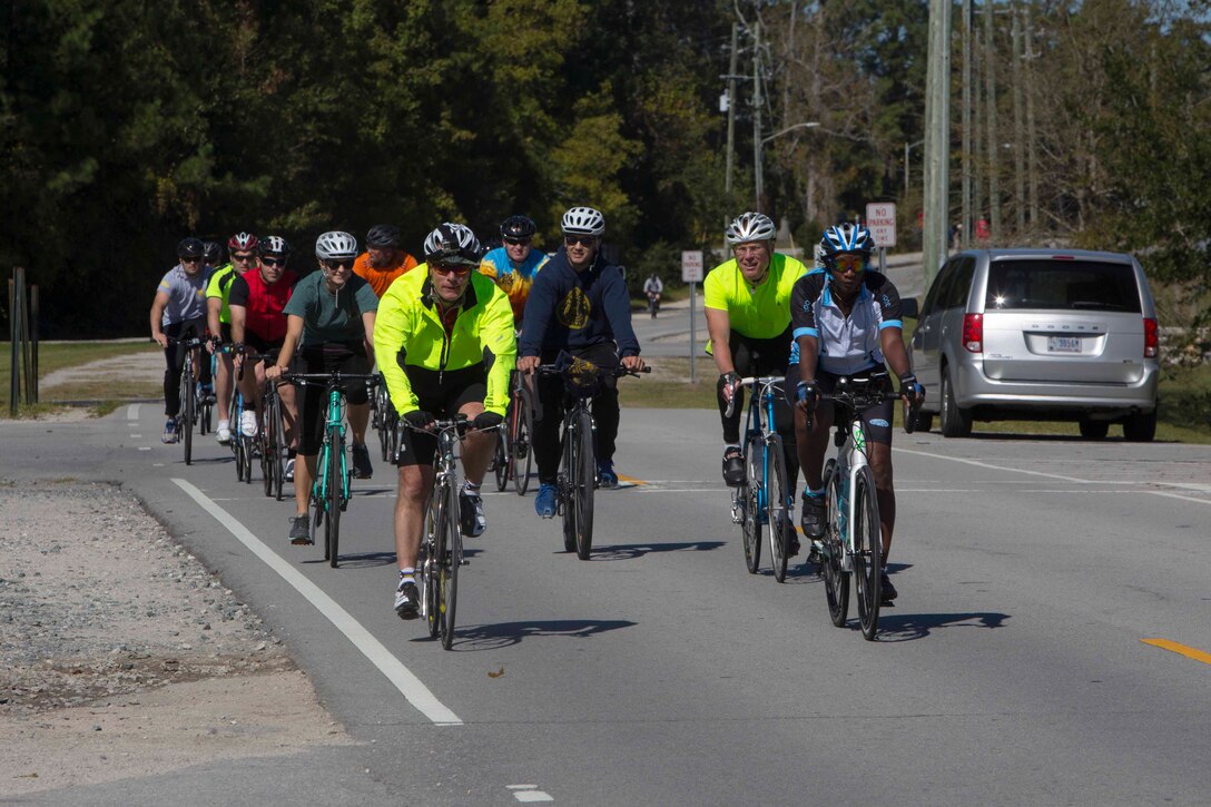 Marines and Sailors ride in a group towards the end point during a unit bike ride at Camp Lejeune, N.C. Oct. 18, 2017. The bike ride afforded participants the opportunity to come together and strengthen unit cohesion and camaraderie. The Participants are with 2nd Marine Logistics Group. (U.S. Marine Corps photo by Pfc. Nicholas Guevara)