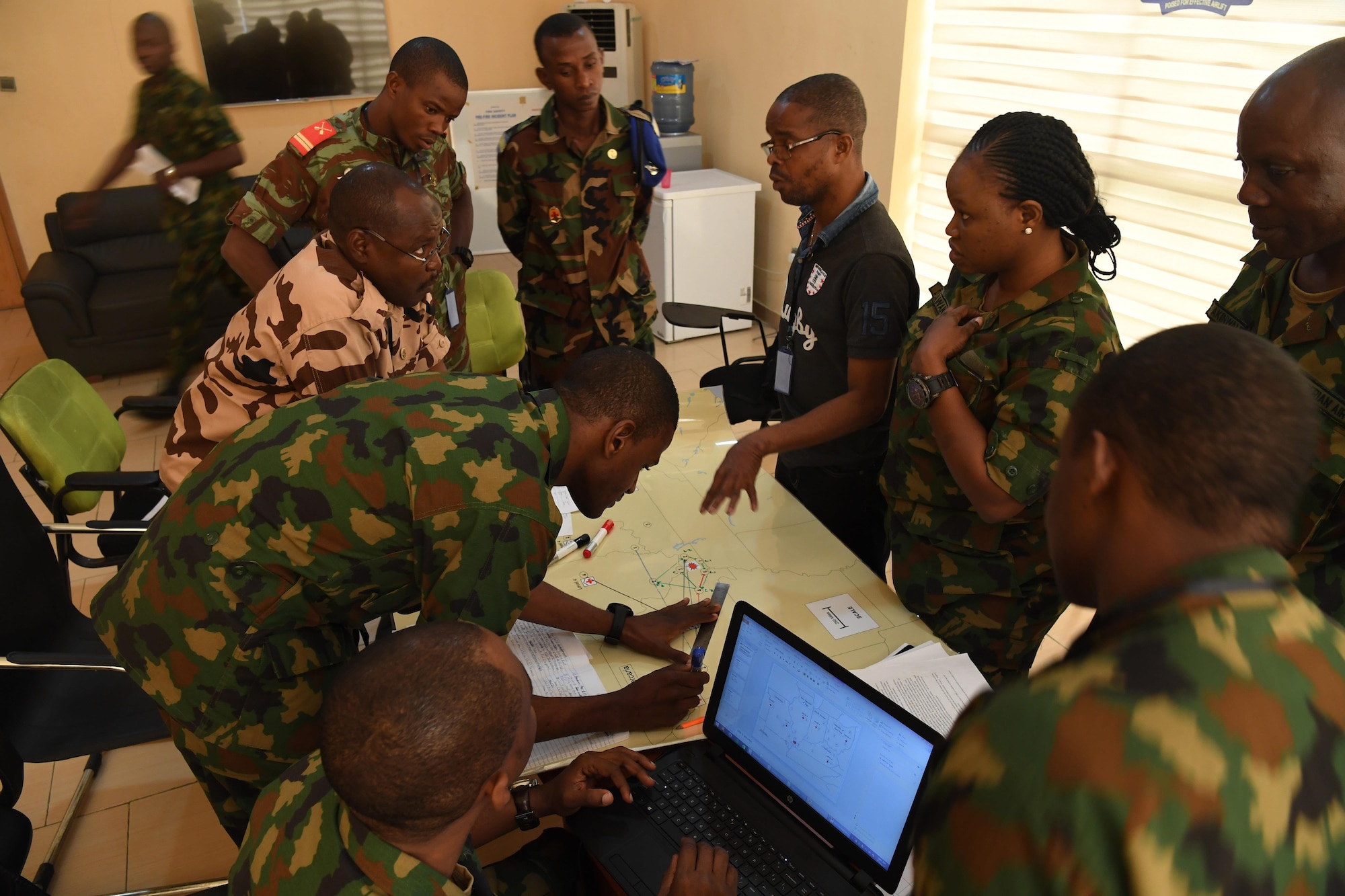 A team of air force members from Nigeria and Chad discuss aeromedical evacuation through a translator during African Partnership Flight Nigeria, Lagos, Nigeria, Aug. 17, 2017.