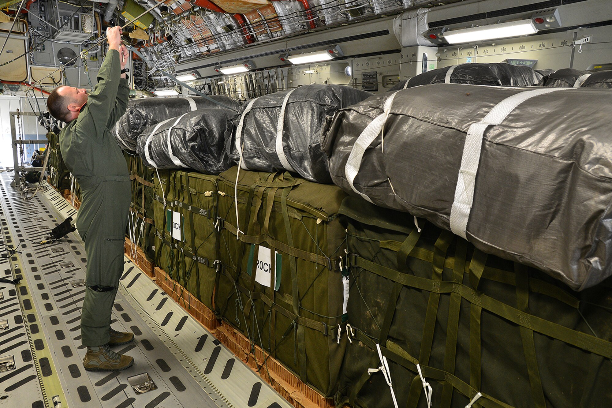 Preparations for CDS air drop. Loadmaster connects the static line.