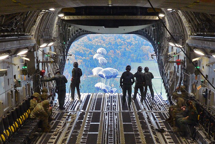 Loadmasters watch the parachutes of the CDS bundles deploy.