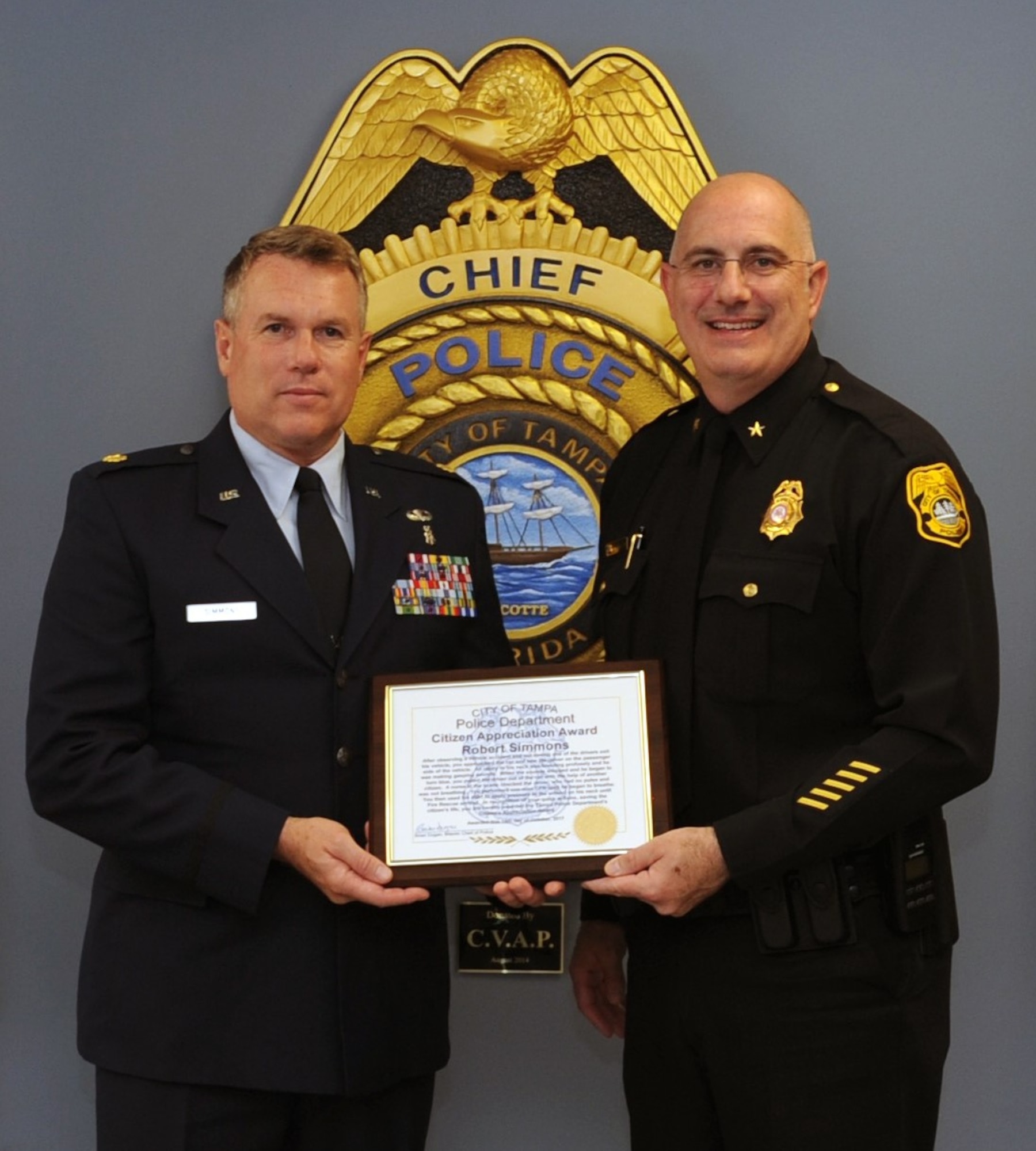 During a ceremony held 19 Oct., Tampa Police Department Interim Chief Brian Dugan (on right) presented Maj. Robert Simmons, 45th Aeromedical Evacuation Squadron, Medical Service Corps Officer, MacDill Air Force Base, Fla., a Citizen Appreciation Award for his lifesaving actions. Simmons was on his way home after the July Unit Training Assembly, when he witnessed a crash that left one victim with life threatening injuries. (U.S. Air Force photo by Tech. Sgt. Peter Dean)