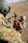 U.S. Army Sgt. Jared Belisle, a crew chief assigned to Company C, 1st General Support Aviation Battalion, 111th Aviation Regiment, Task Force Dragon, guides a German soldier.