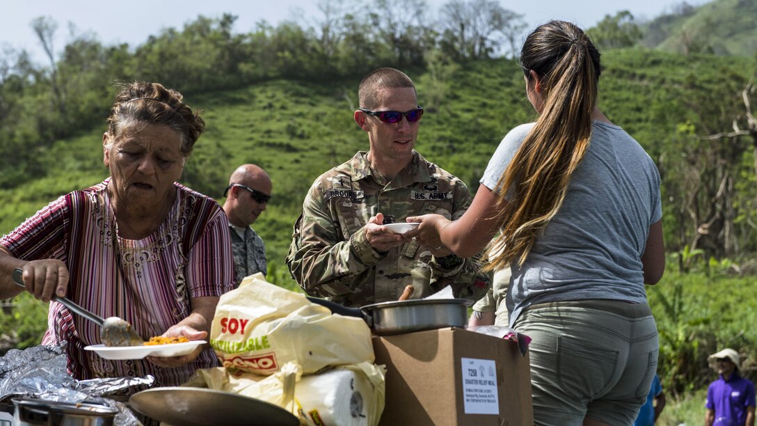 Residents offer meals to service members helping with hurricane relief.