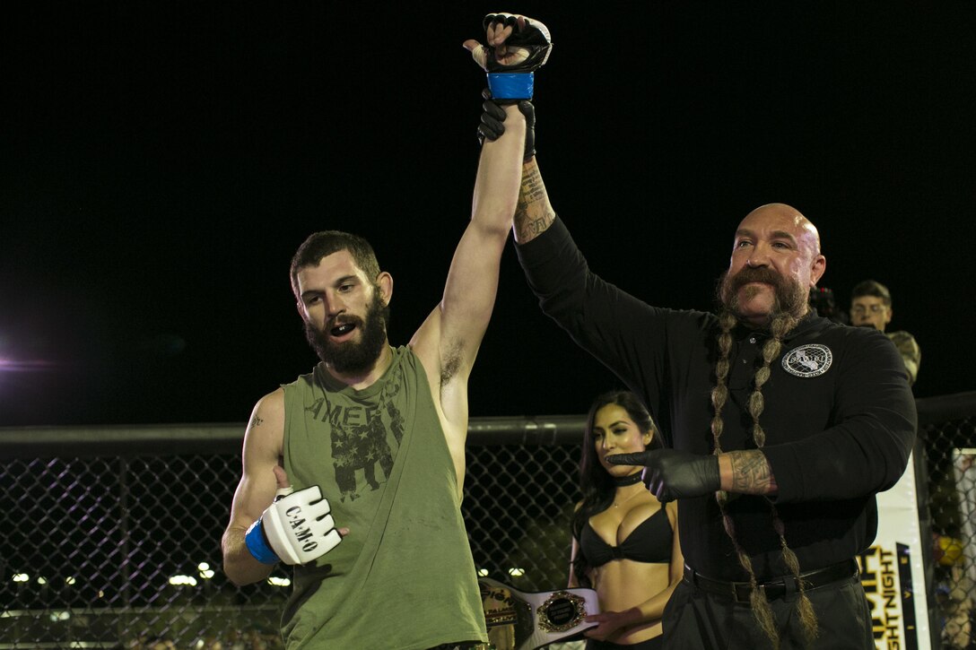 Mike Beltrain, referee, announces Andrew Freelove, Marine Corps retiree, as the winner of Fight Night at Victory Field, aboard the Marine Corps Air Ground Combat Center, Twentynine Palms, Calif., Oct. 13, 2017. Fight Night is an annual event hosted by Marine Corps Community Services to boost the morale of service members aboard the Combat Center. (U.S. Marine Corps photo by Lance Cpl. Isaac Cantrell)