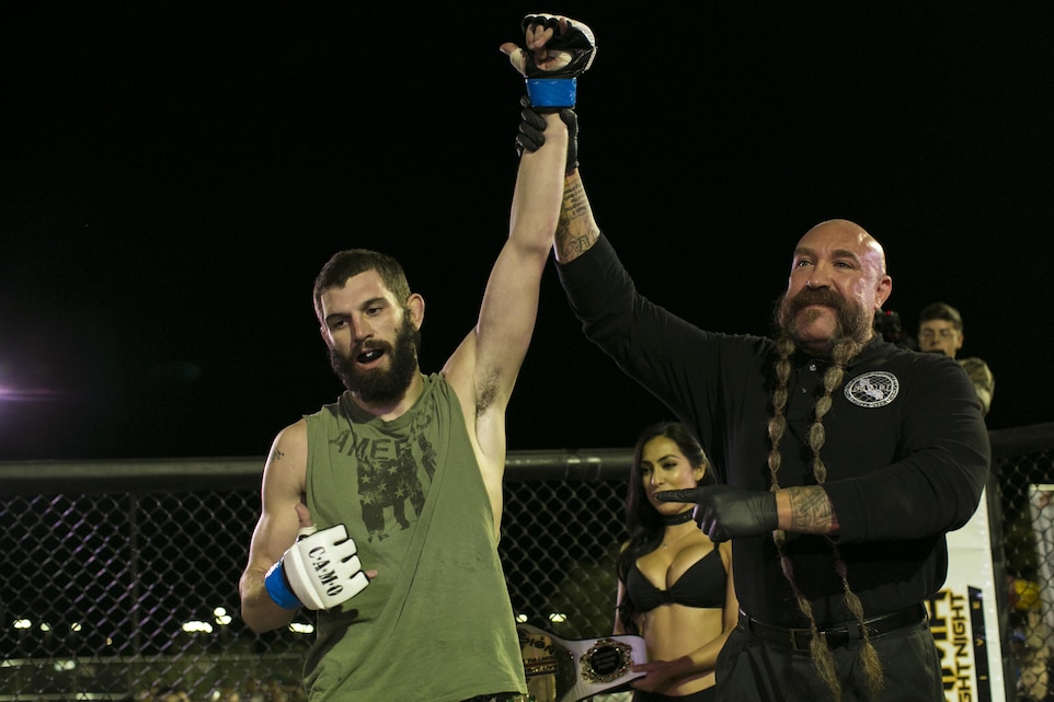 Mike Beltrain, referee, announces Andrew Freelove, Marine Corps retiree, as the winner of Fight Night at Victory Field, aboard the Marine Corps Air Ground Combat Center, Twentynine Palms, Calif., Oct. 13, 2017. Fight Night is an annual event hosted by Marine Corps Community Services to boost the morale of service members aboard the Combat Center. (U.S. Marine Corps photo by Lance Cpl. Isaac Cantrell)