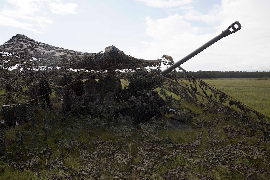 A Marine field artillery cannoneer and British commando gunners prepare to fire an M119A3 Howitzer during field artillery training at Camp Lejeune, N.C., Oct. 11, 2017. British soldiers exchanged knowledge and skills with U.S. Marines to refine their artillery operation capabilities in preparation for joint exercise Bold Alligator, a large-scale, multinational Naval amphibious exercise to execute complex shaping, amphibious, and sea basing operations to improve U.S. and coalition ship-to-shore capabilities. The Marines are with 2nd Battalion, 10th Marine Regiment and the British soldiers are with 29 Commando Regiment, Royal Artillery. (U.S. Marine Corps photo by Pfc. Nicholas Guevara)