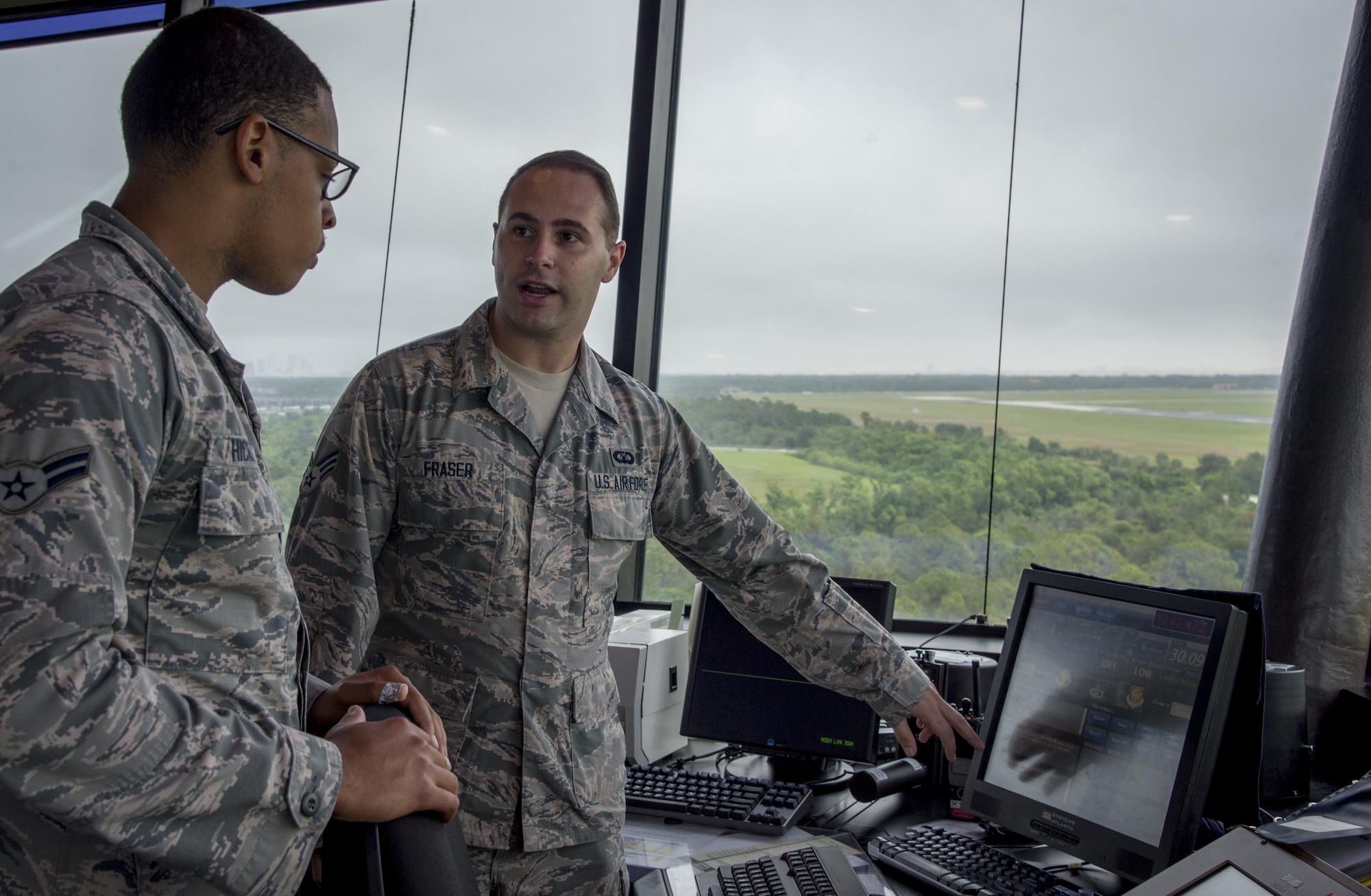 U.S. Air Force Senior Airman Matthew Fraser, an air traffic controller assigned to the 6th Operations Support Squadron, right, talks to Airman 1st Class Keith Hickson Jr., left, a cable and antenna maintenance technician assigned to the 6th Communications Squadron, about what he does on a daily basis during a Shadow Program at MacDill Air Force Base, Fla. Oct. 18, 2017. Each month, Airmen from various squadrons visit each other for typically a day as a part of the MacDill Shadow Program. (U.S. Air Force photo by Senior Airman Mariette Adams)