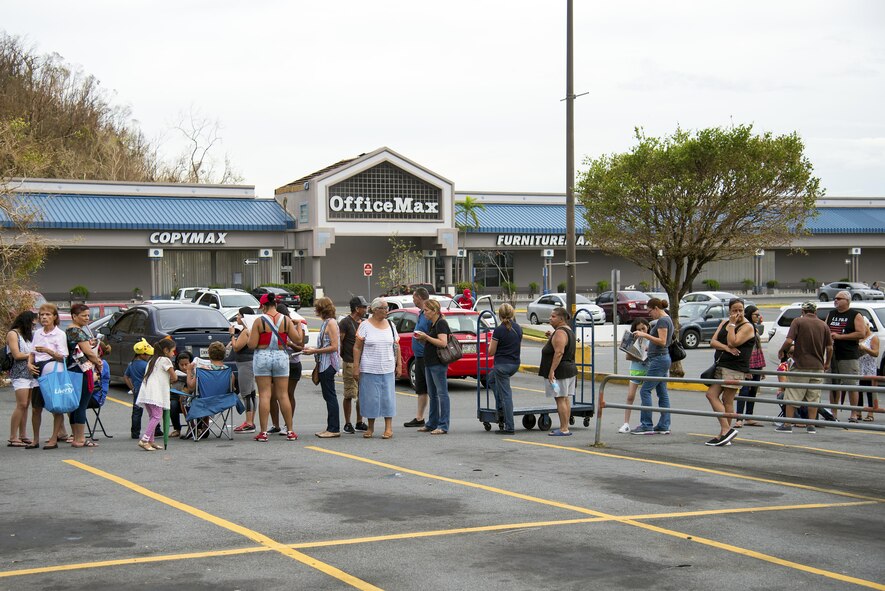 Citizens of Puerto Rico line up to buy essential supplies in Bayamon, Puerto Rico, Sept. 30, 2017. Due to the line’s length, people brought their own chairs to comfortably wait for an opportunity to purchase food and water rations