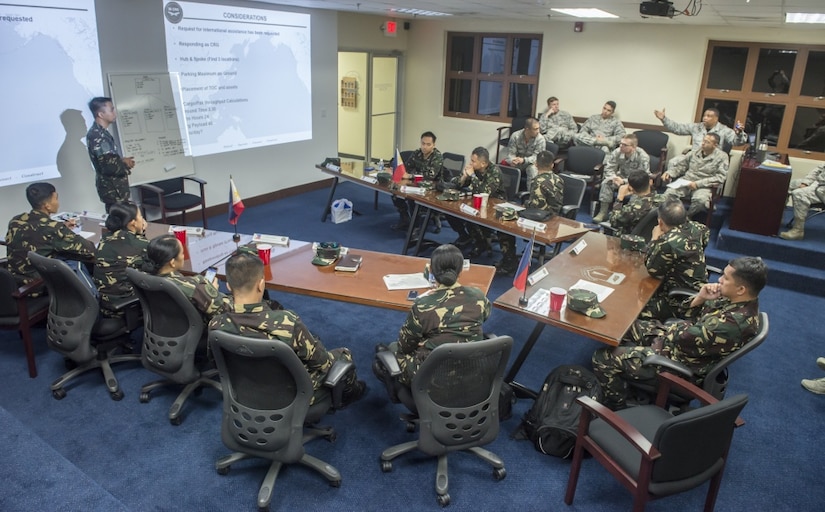 Members of the Philippine air force brief American airmen assigned to the 36th Contingency Response Group after a disaster response planning tabletop exercise during Pacific Responder 17 at Andersen Air Force Base, Guam.