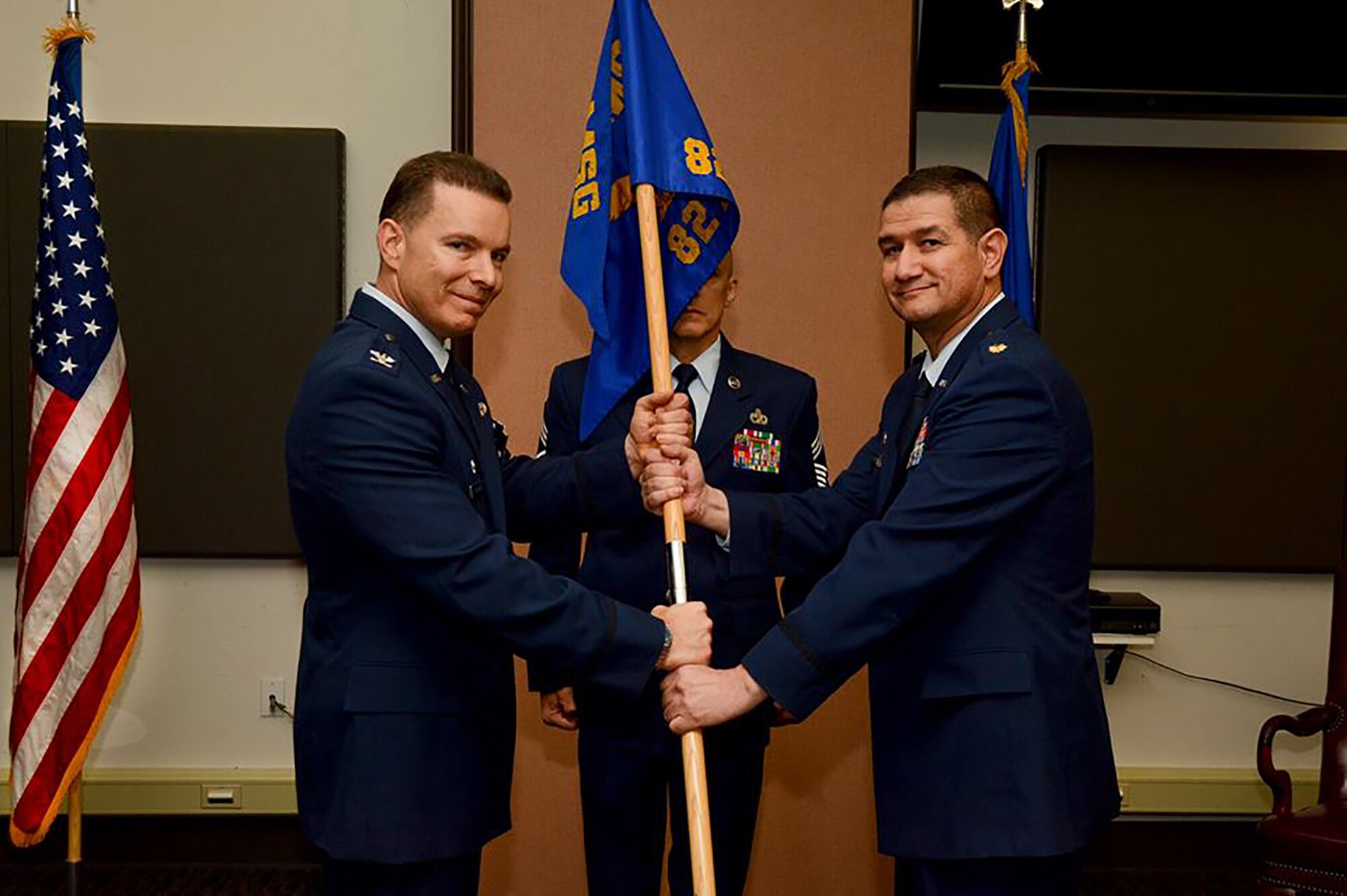 Maj. Charles Marquez accepts the 82nd Aerial Port Squadron guidon from Col. Roderick T. Grunwald, 349th Mission Support Group commander, during an assumption of command ceremony at Travis Air Force Base, Calif., Oct. 14, 2017.