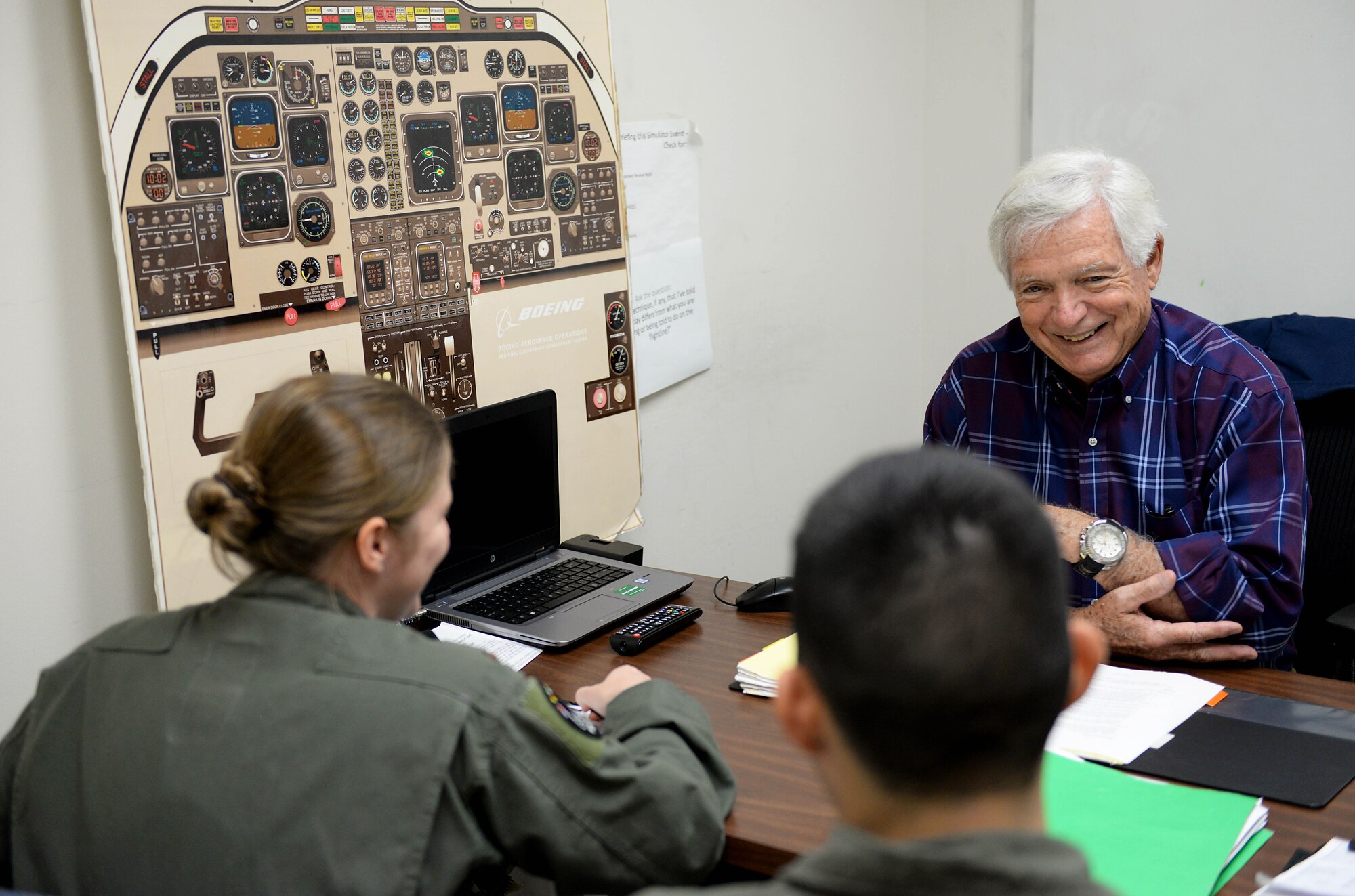 Dale Hopkins, T-1A Jayhawk simulation instructor pilot, briefs two student pilots before a simulated flight Oct. 17, 2017, on Columbus Air Force Base, Mississippi. Hopkins has over 50 years of Air Force experience he’s able to offer the newest Air Force aviators. (U.S. Air Force photo by Airman 1st Class Keith Holcomb)