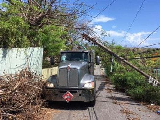 A fuel truck contracted by the Defense Logistics Agency makes its way through fallen electrical poles and downed trees in Puerto Rico.