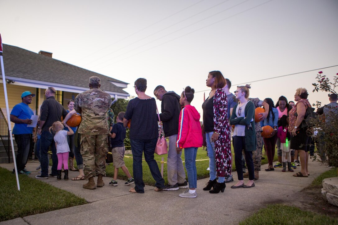 Residents of The Village at Federal City, in New Orleans, stand in line to receive a prize after participating in a pumpkin-patch dash, Oct. 17, 2017. Police officers with New Orleans Police Department, along with Marines from Marine Forces Reserve, held “A Night Out Against Crime”, a yearly, nationwide event that brings together community members in a police-to-community partnership to raise awareness of a police presence, and to build safety in surrounding areas of New Orleans. (U.S. Marine Corps photo by Cpl. Dallas Johnson/Released)