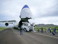 Members of the 821st Contingency Response Group help to offload line trucks from a Ukrainian Anatov 124-100m cargo transporter onto the tarmac of Jose Aponte De La Toore Airport in Ceiba, Puerto Rico, Oct. 11, 2017. The line trucks will be used to help repair the electrical grid in Puerto Rico that was destroyed after Hurricane Maria devastated the island.
