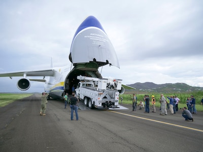 Members of the 821st Contingency Response Group help to offload line trucks from a Ukrainian Anatov 124-100m cargo transporter onto the tarmac of Jose Aponte De La Toore Airport in Ceiba, Puerto Rico, Oct. 11, 2017. The line trucks will be used to help repair the electrical grid in Puerto Rico that was destroyed after Hurricane Maria devastated the island.