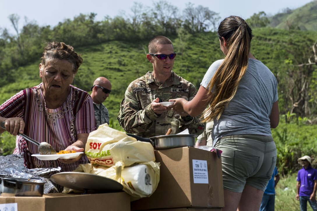 Residents offer meals to service members helping with hurricane relief.