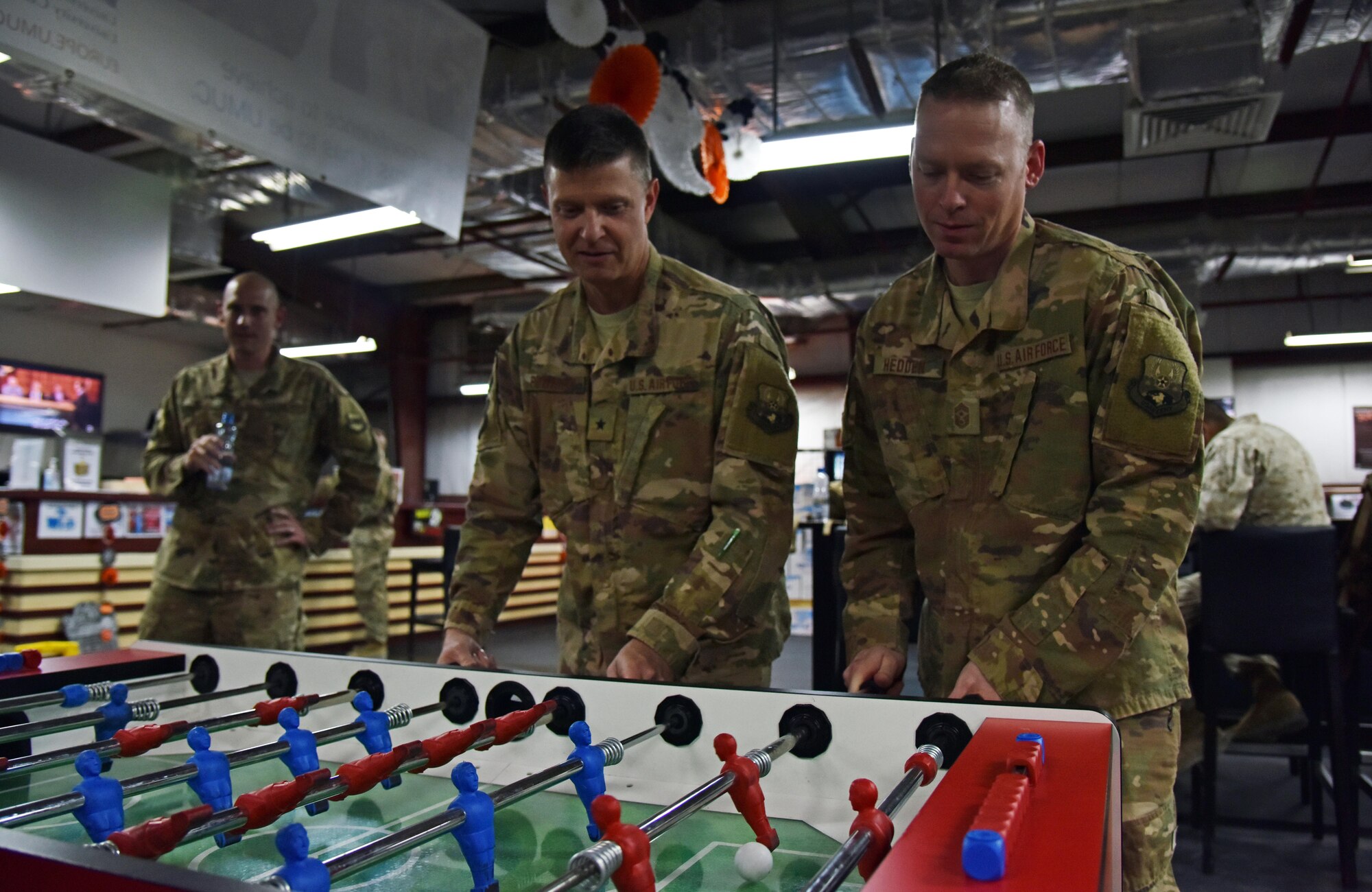 U.S. Air Force Brig. Gen. Kyle Robinson, 332nd Air Expeditionary Wing commander, and Chief Master Sgt. Benjamin Hedden, 322nd AEW command chief, play foosball at the moral, welfare and recreation center Oct. 20, 2017, in Southwest Asia. Robinson and Hedden toured various moral, welfare and recreation areas during their visit. (U.S. Air Force photo by Staff Sgt. Joshua Edwards/Released)