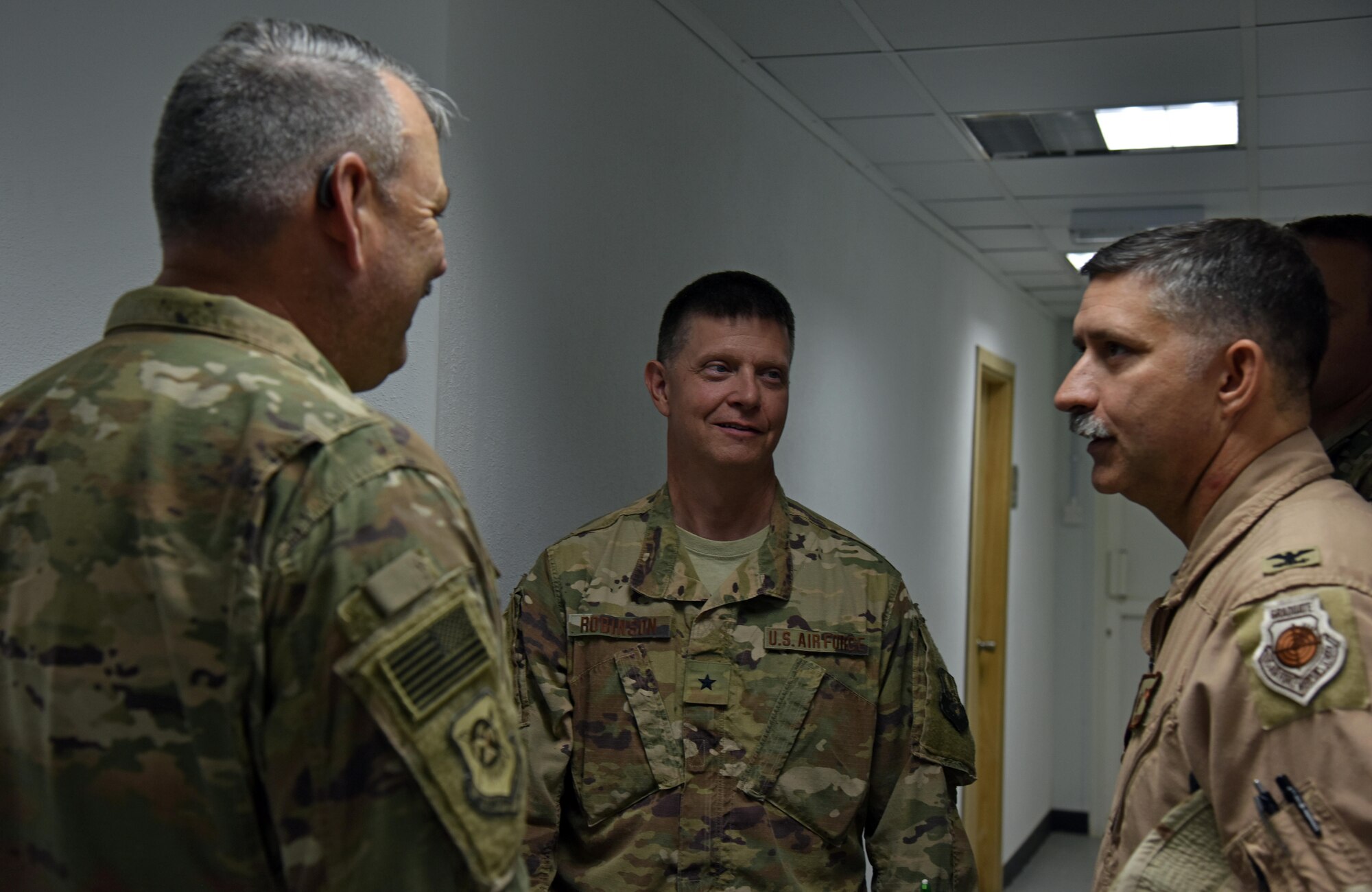 U.S. Air Force Brig. Gen. Kyle Robinson, 332nd Air Expeditionary Wing commander, speaks with Col. John Gonzalez, 407th Air Expeditionary Group commander, and Chief Master Sgt. Jeremy Grider, 407 AEG command chief, Oct. 20, 2017, in Southwest Asia. Group leadership gave Robinson a tour of the base and introduced him to star performers. (U.S. Air Force photo by Staff Sgt. Joshua Edwards/Released)