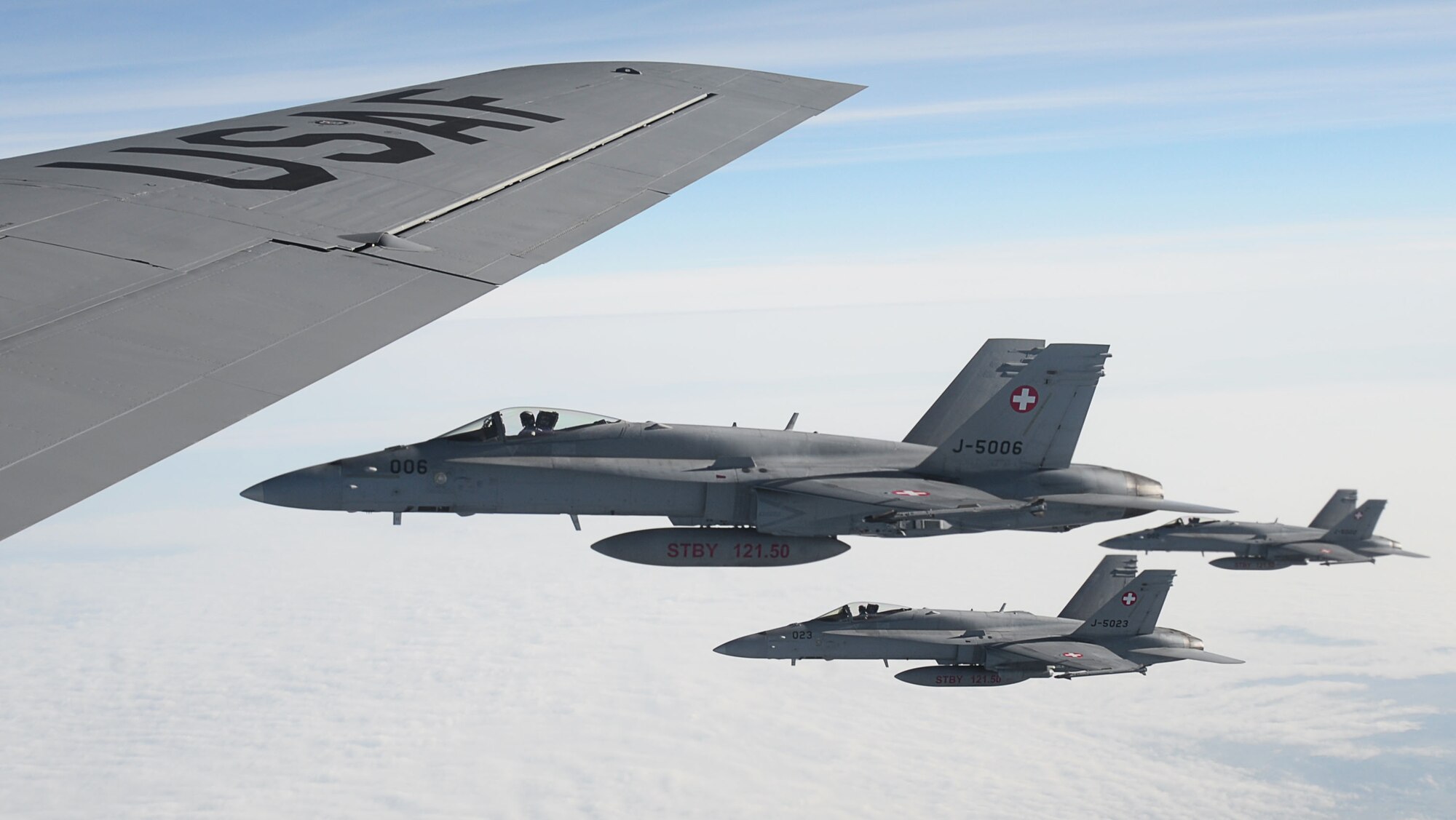 Three Swiss air force F-18 Hornets fly alongside a U.S. Air Force KC-135 Stratotanker, assigned to the 100th Air Refueling Wing RAF Mildenhall, England, after aerial refueling, Oct. 20, 2017. Four F-18s received fuel during a training mission over Germany. (U.S. Air Force photo by Senior Airman Justine Rho)