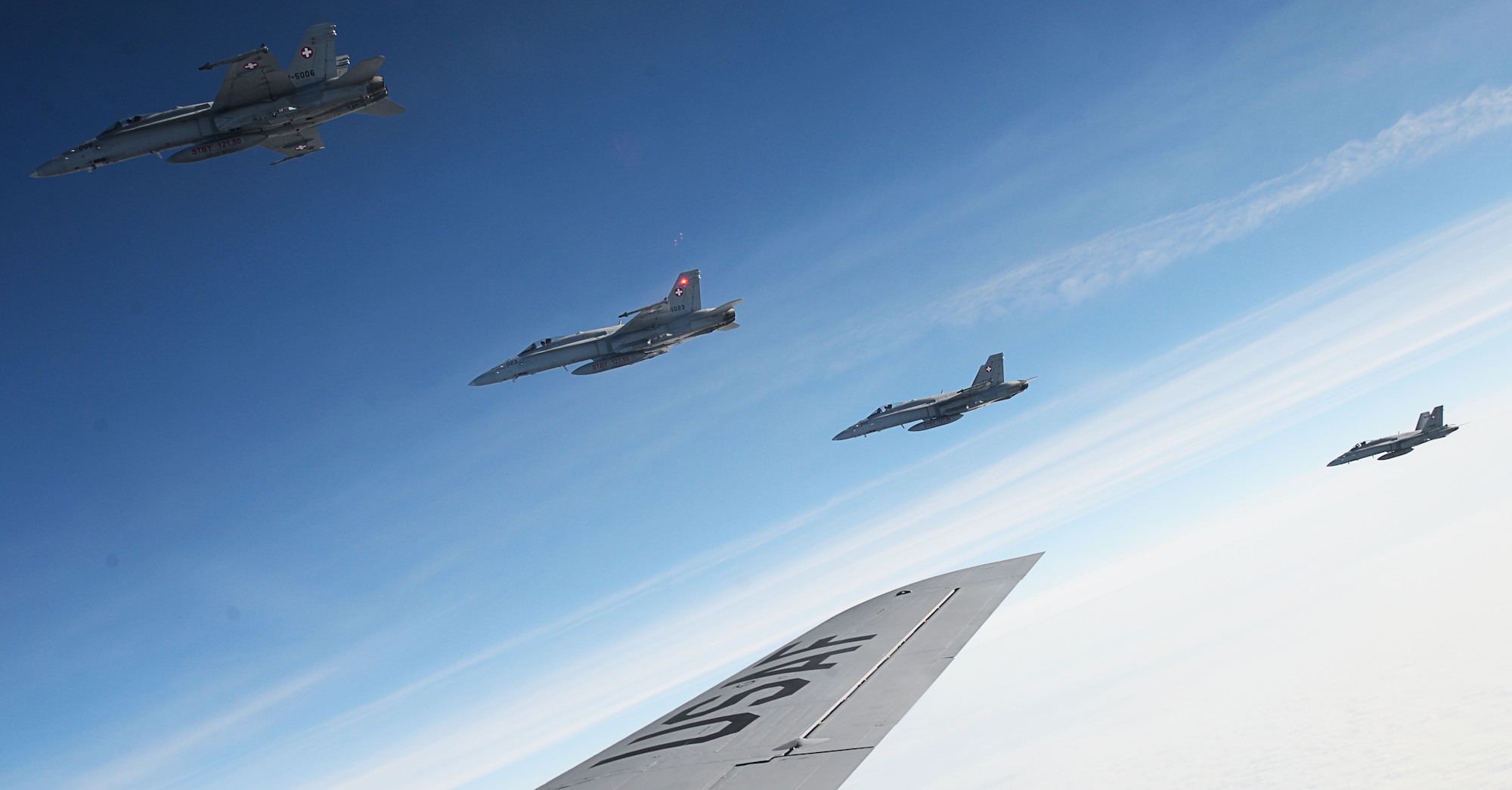 Four Swiss F-18 Hornets fly alongside a U.S. Air Force KC-135 Stratotanker, assigned to the 100th Air Refueling Wing RAF Mildenhall, England, after receiving fuel over Germany Oct. 20, 2017. The 100th ARW theatre of operations covers Europe and Africa, supporting NATO and other nation missions. (U.S. Air Force photo by Senior Airman Justine Rho)