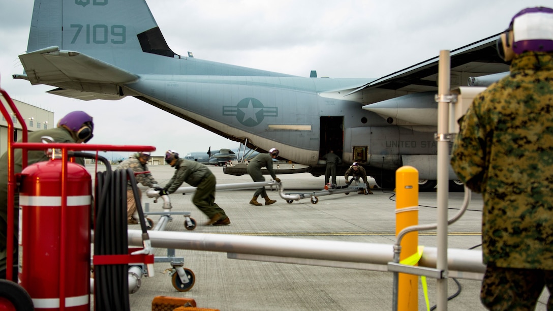 U.S. Marines and Master Labor Contractors with the Logistics Department Fuels Division fold in the Aircraft Direct Fueling System