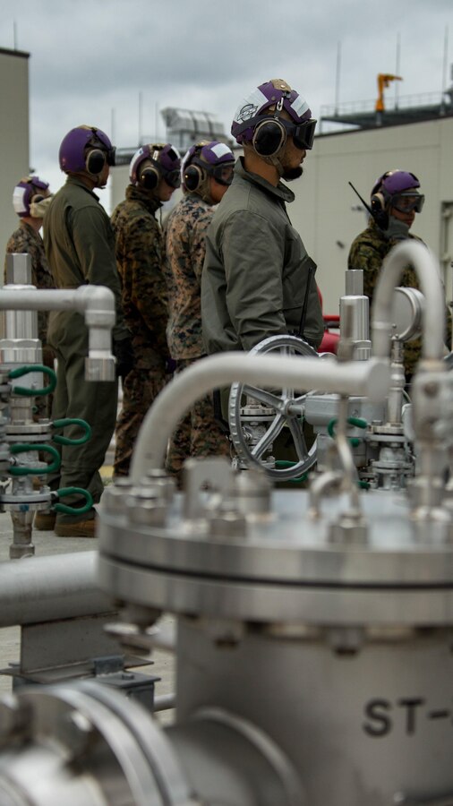 U.S. Marines and Master Labor Contractors with the Logistics Department Fuels Division observe the Aircraft Direct Fueling System (ADFS) during the first hot refuel utilizing the new system at Marine Corps Air Station Iwakuni, Japan, Oct. 19, 2017. The ADFS allows the aircraft to rotate crew, take on cargo or Marines and keep its engines running while accepting fuel. This training marked the first refueling evolution at the new hot refueling pit designed to distribute fuel to Type-4 aircraft such as the KC-130J Hercules, MV-22 Osprey and MH-60 helicopter. (U.S. Marine Corps photo by Cpl. Donato Maffin)