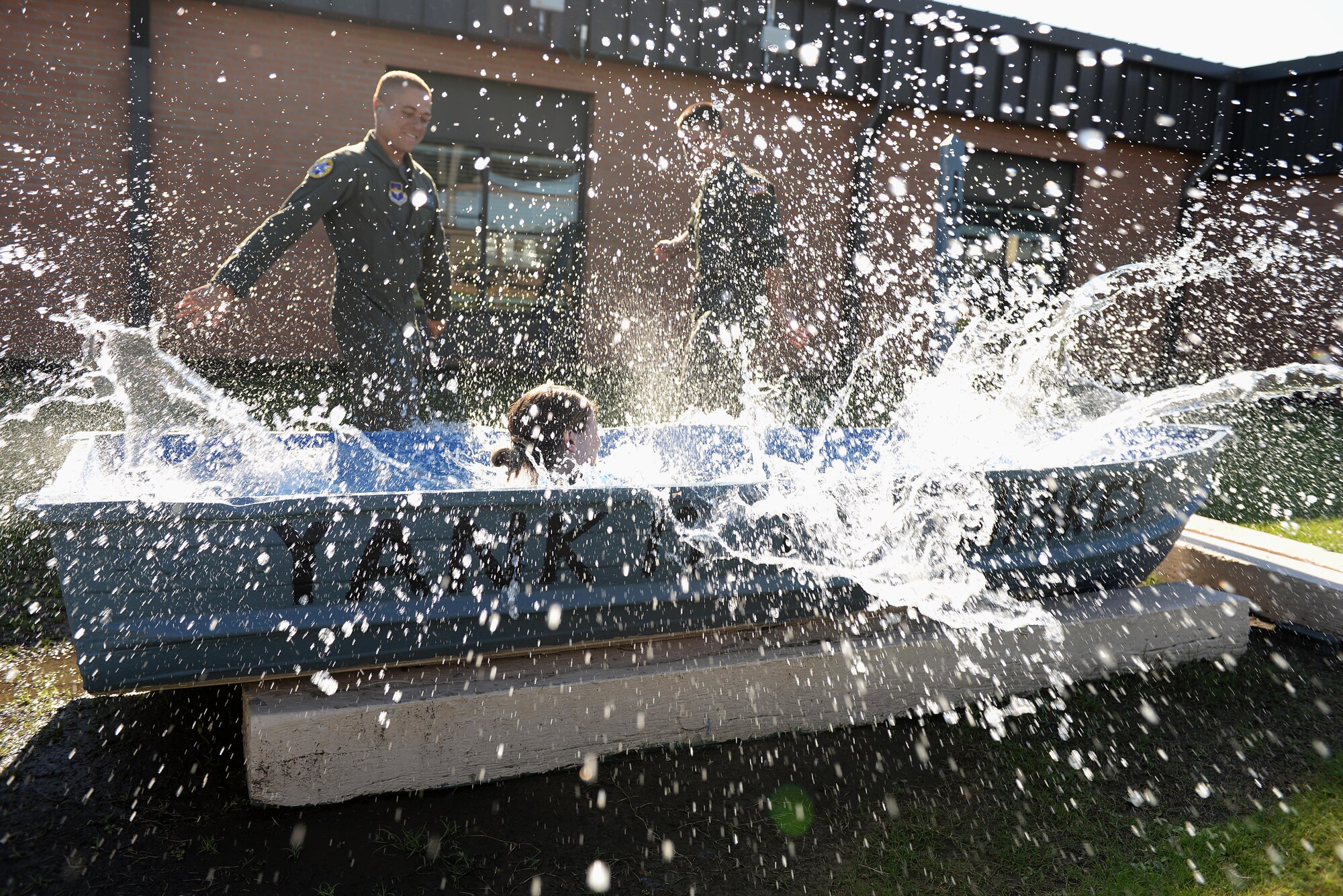 Second Lt. Kason Pifer, and Zachary Tarbox, 37th Flying Training Squadron student pilots, help 2nd Lt. Rachael Grant, 37th FTS student pilot, into a pool Oct. 13, 2017, on Columbus Air Force Base, Mississippi. Student pilots swim in their squadron’s pool when the student successfully completes their first solo-flight. (U.S. Air Force photo by Airman 1st Class Keith Holcomb)