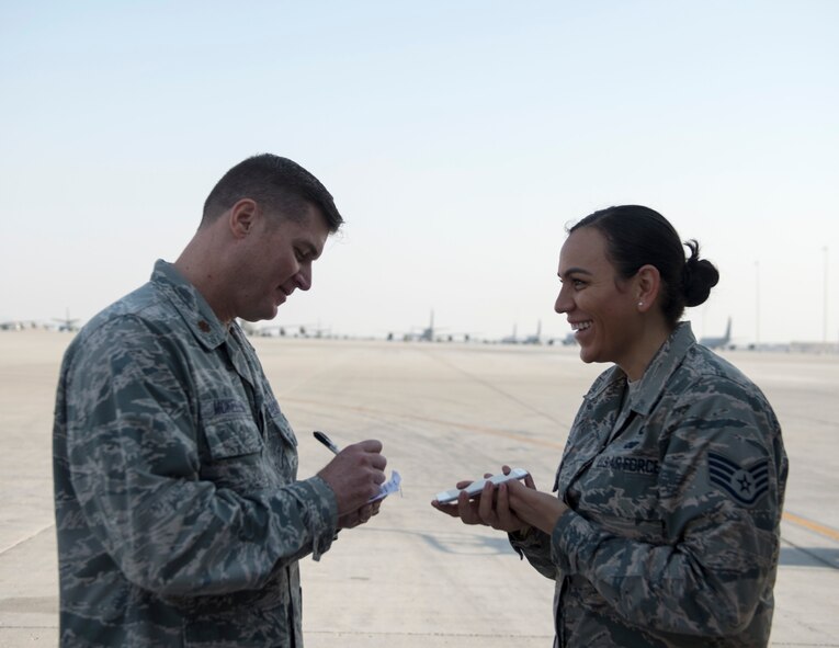 U.S. Air Force Chaplain (Maj.) Mark McKellen, with the 379th Air Expeditionary Wing Chapel, writes out the oath of enlistment at Al Udeid Air Base, Qatar, Oct. 3, 2017.