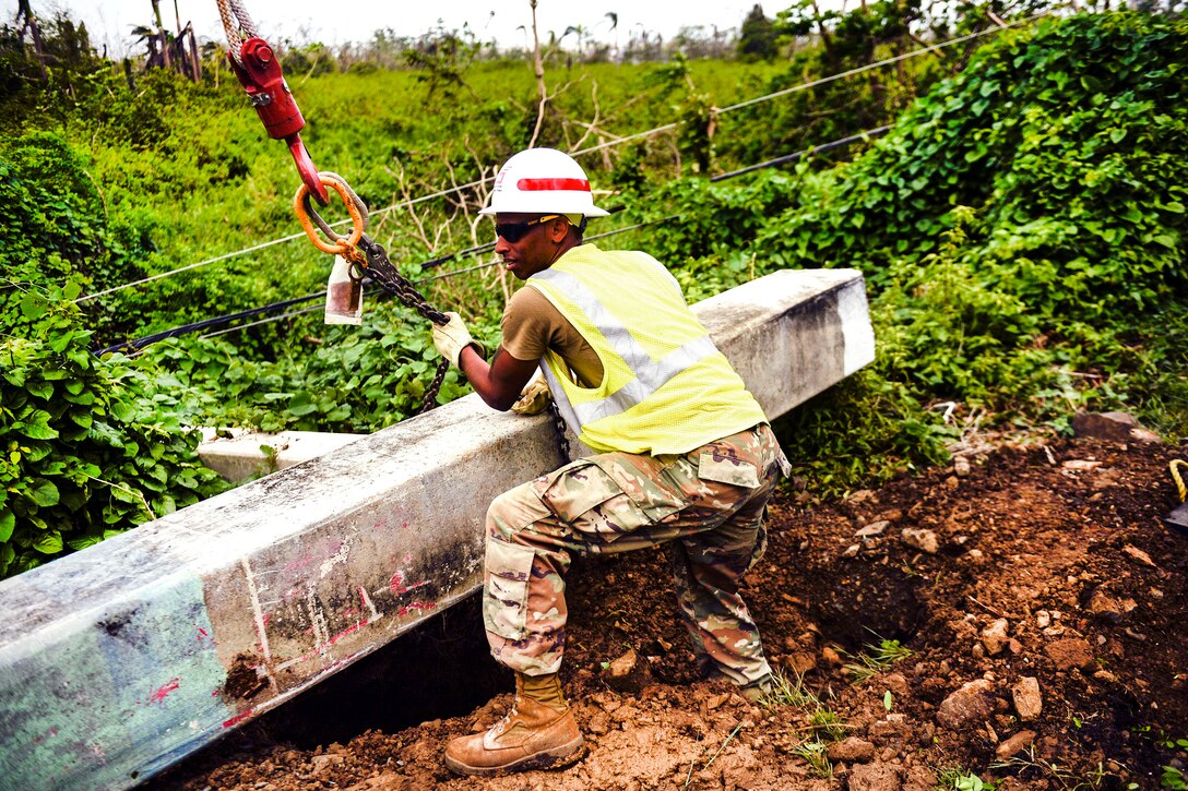 An Army reservist prepares to set a power pole in Puerto Rico.