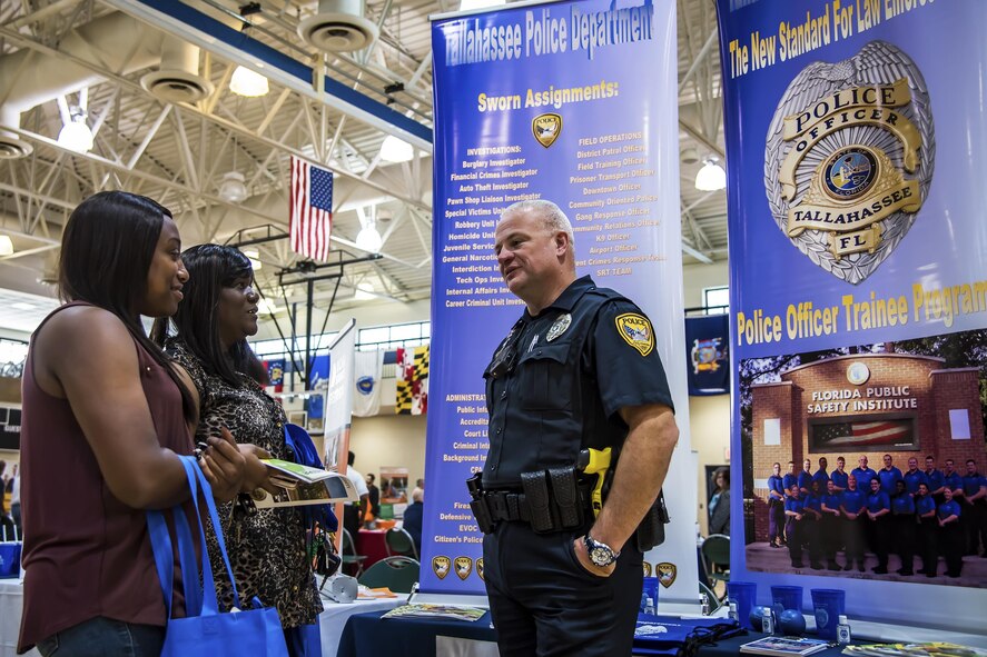 Paul Donaldson, right, Tallahassee Police Department policeman, speaks to Pamela Cherry and Toccora Ferguson, contract custodians, during the Veterans career fair Oct. 19, 2017, at Moody Air Force Base, Ga. Over 55 potential employers were present to network with attendees, compete for hiring opportunities and schedule interviews. (U.S. Air Force photo by Airman Eugene Oliver)