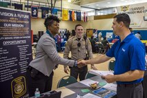 Sabrina Smith, sergeant detective for the Valdosta Police Department shakes hands with Bart Larson, maintenance specialist for Hunt family housing, during the veterans career fair Oct. 20, 2017 at Moody Air Force Base, Ga. Over 55 potential employers were present to network with attendees, compete for hiring opportunities and schedule interviews. (U.S. Air Force photo by Airman Eugene Oliver)