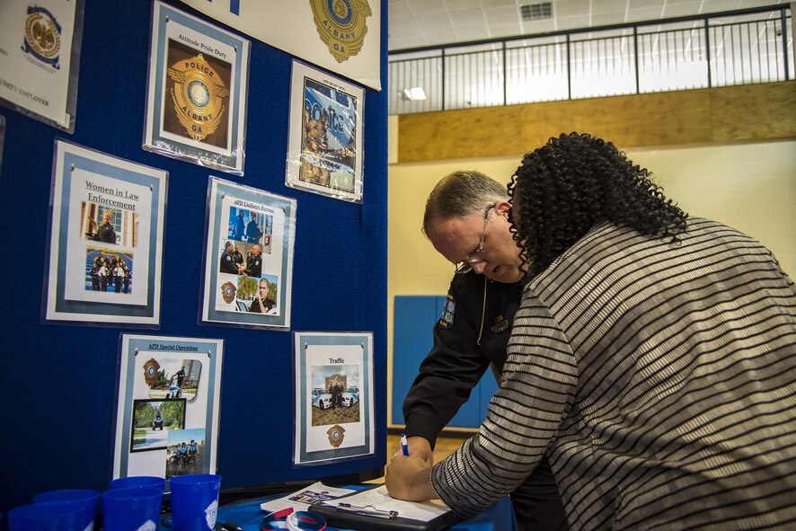 Lashawnya Harris, local community member, signs a contact sheet with Larry Myers, Albany County policeman during the veteran’s career field Oct. 20, 2017, at Moody Air Force Base, Ga. Over 55 potential employers were present to network with attendees, compete for hiring opportunities and schedule interviews. (U.S. Air Force photo by Airman Eugene Oliver)