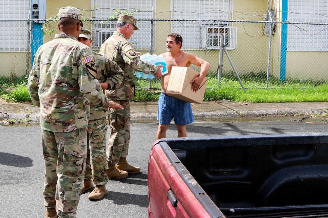 Soldiers deliver relief supplies to a resident of Puerto Rico.