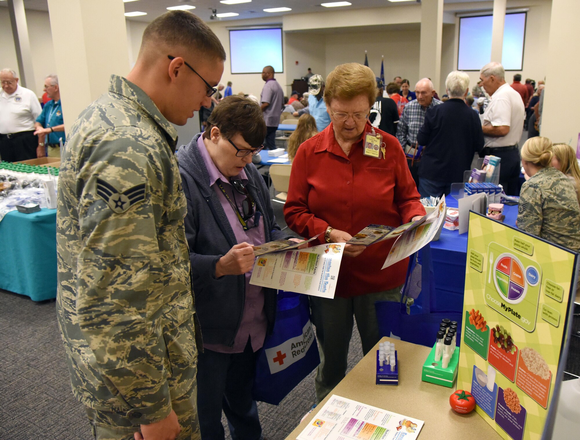Senior Airman Juan Acevedo, 81st Diagnostic and Therapeutics Squadron diet therapy technician, provides informational pamphlets to U.S. Navy retired Senior Chief Petty Officer Faye Jefferson and U.S. Marine retired Sgt. Maj. Doris Denton during Retiree Appreciation Day at the Roberts Consolidated Aircraft Maintenance Facility Oct. 20, 2017, on Keesler Air Force Base, Mississippi. The annual event, sponsored by the Keesler Retiree Activities Office, included more than 20 displays with information pertinent to retirees and a free lunch. (U.S. Air Force photo by Kemberly Groue)