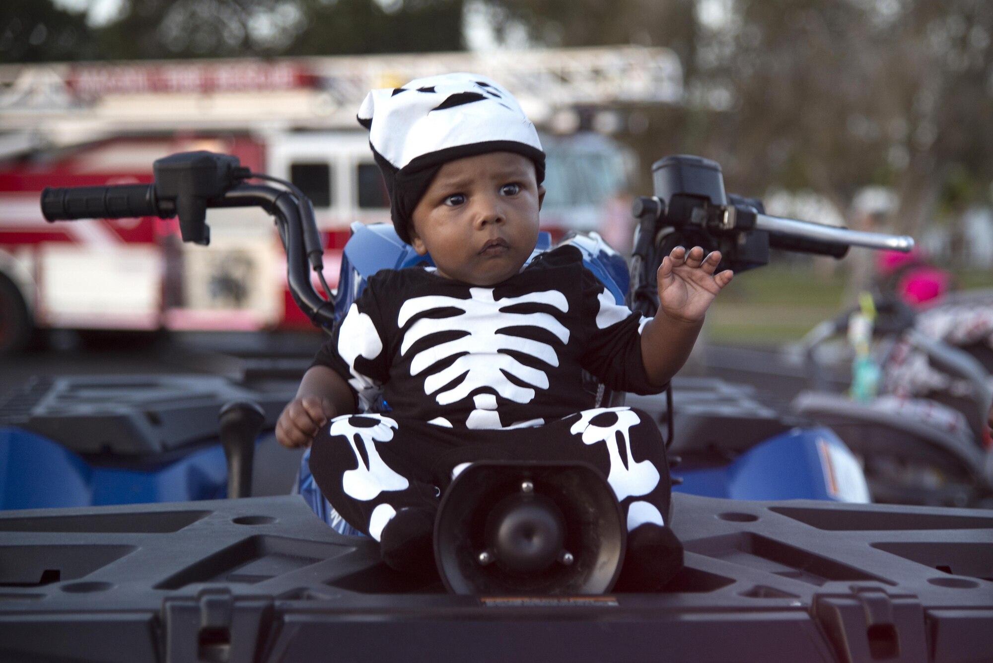 A child sits on the front of an all-terrain vehicle from the 6th Security Forces Squadron during the MacThrillville Fall Festival at MacDill Air Force Base, Fla., Oct. 20, 2017.