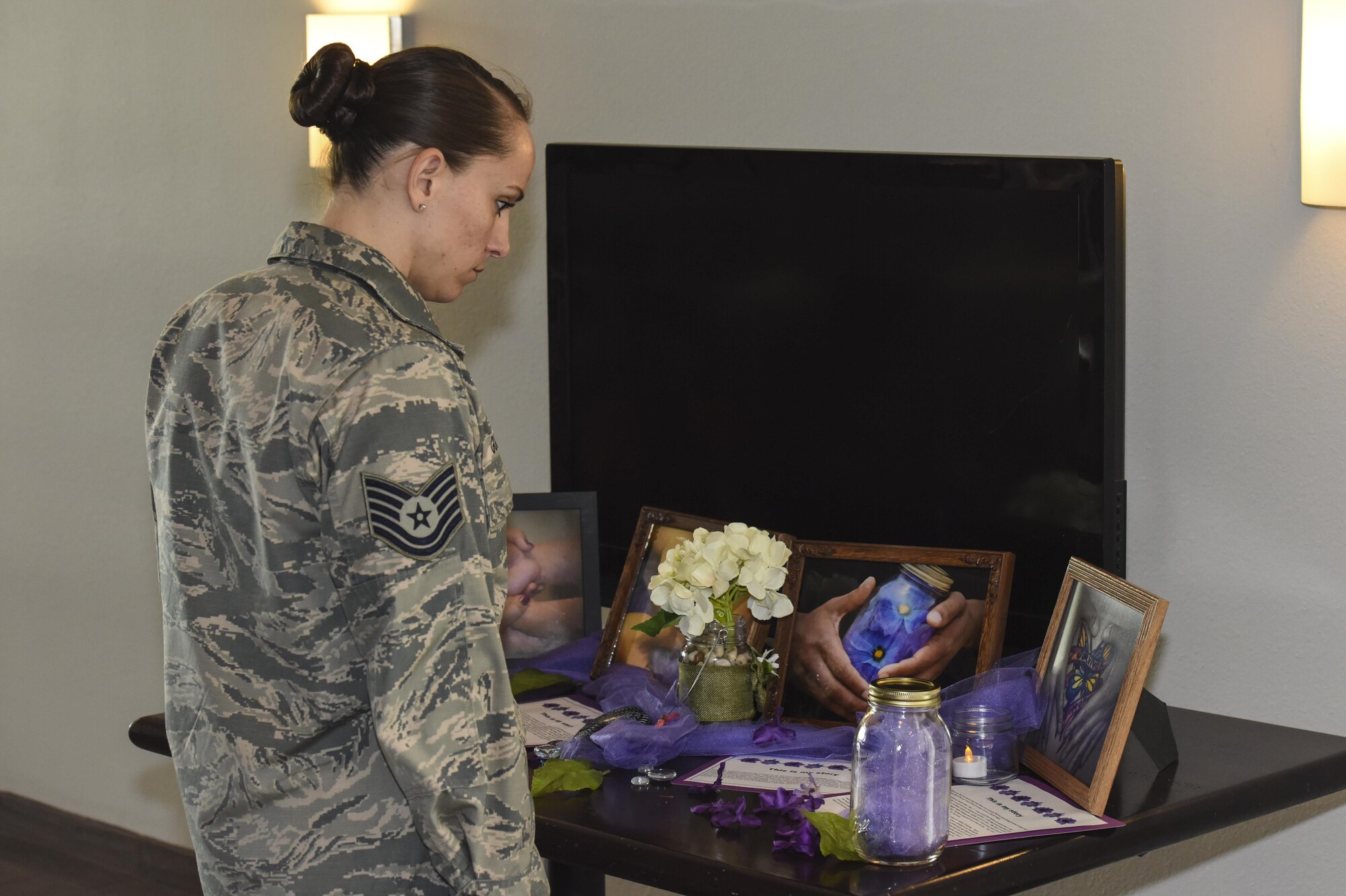 Tech. Sgt. Stephanie Godsey, 315th Training Squadron instructor, looks at a display during the Domestic Violence Awareness Month proclamation signing at the Event Center on Goodfellow Air Force Base, Texas, Oct. 20, 2017.  Each table had displays sharing stories of survivors of domestic abuse. (U.S. Air Force photo by Airman 1st Class Zachary Chapman/Released)