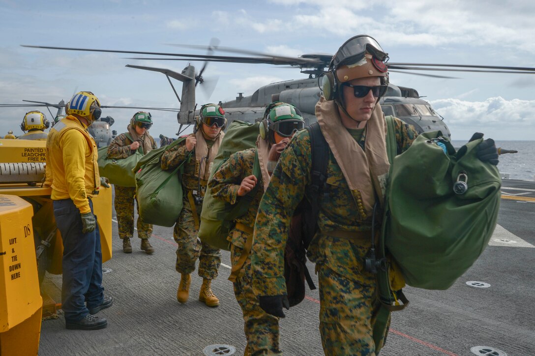 Marines assigned to Marine Heavy Helicopter Squadron 361 come aboard the amphibious assault ship USS Essex.