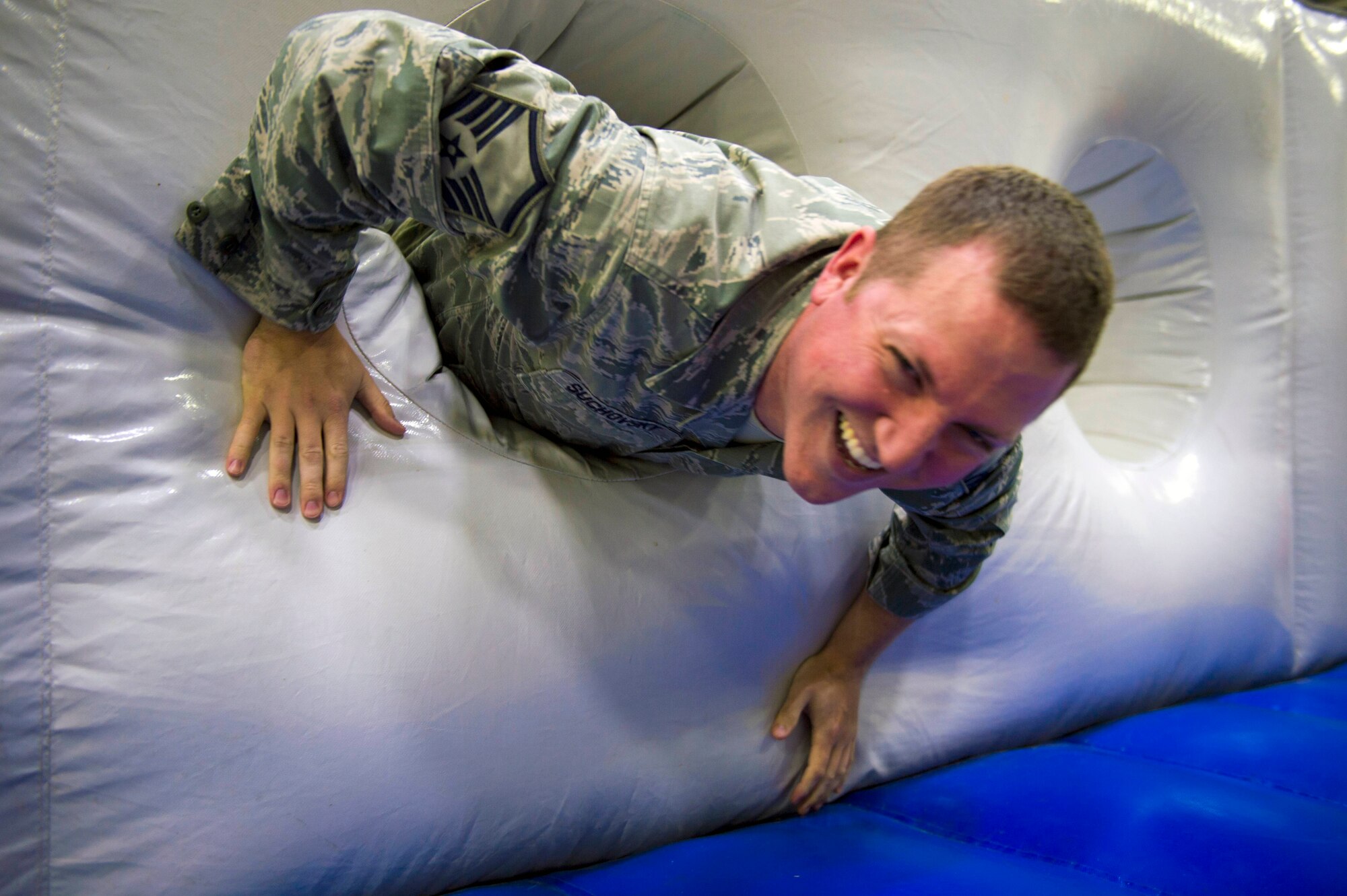 Master Sgt. Joshua Suchovsky, 434 Operations Group information manager, crawls out of an inflatable obstacle course during Wingman Day at Grissom Air Reserve Base, Ind., October 15, 2017. Wingman Day is a Reserve-wide event held each year to bring Airmen together in a relaxed environment and encourage them to become better wingmen. (U.S. Air Force photo/ Senior Airman Harrison Withrow)