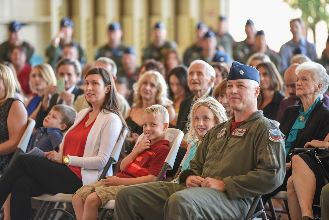 Lt. Col. Ryan Savageau, 944th Operations Group deputy commander, sits with his two children, Colbie and Luke, during the 69th Fighter Squadron change of command ceremony Oct. 10. Savageau's spouse, Lt. Col. Trena Savageau, incoming 69th Fighter Squadron commander, thanked her family and friends for their support throughout her career.