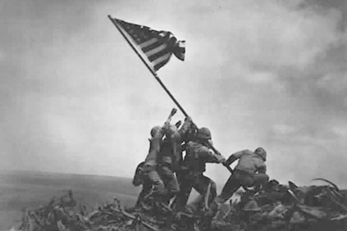 Service members raise the American Flag on Mount Suribachi, Japan.