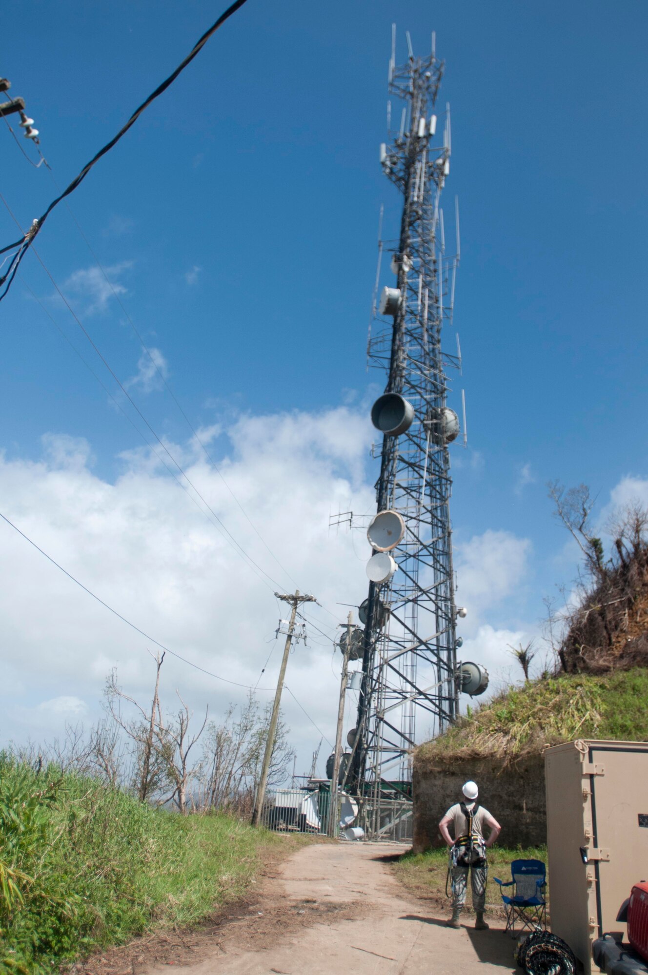 An airman with the 85th Engineering and Installation Squadron, 38th Cyberspace Engineering Installation Group, 688th Cyberspace Wing from Keesler Air Force Base, Mississippi looks up at a radio tower where his team is working October 20, 2017 at Cerra de Punta mountain near Ponce, Puerto Rico. The 85th EIS are working to reestablish and improve radio communications for local emergency personnel and first responders across the island.