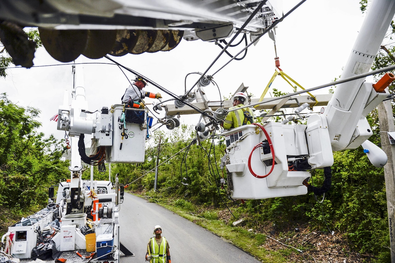Teams using equipment work to repair power lines in Puerto Rico.